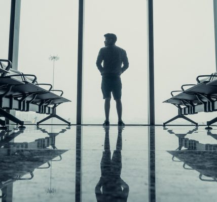 silhouette of man standing in front of glass window