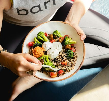 a woman is holding a bowl of food