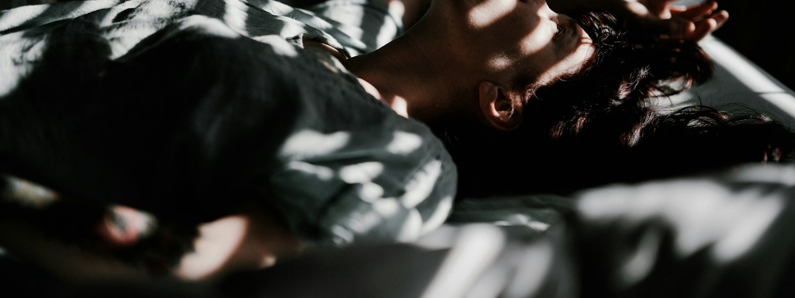 a person laying in bed with their head on a pillow