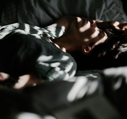 a person laying in bed with their head on a pillow