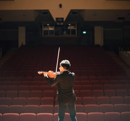 man standing in front of stage playing violin