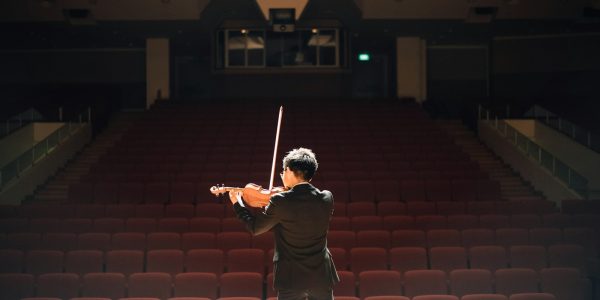 man standing in front of stage playing violin