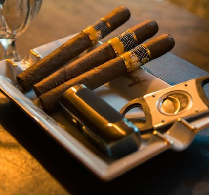 three cigar beside cutter on ashtray