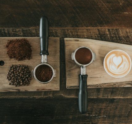 coffee beans beside coffee powder on brown wooden board