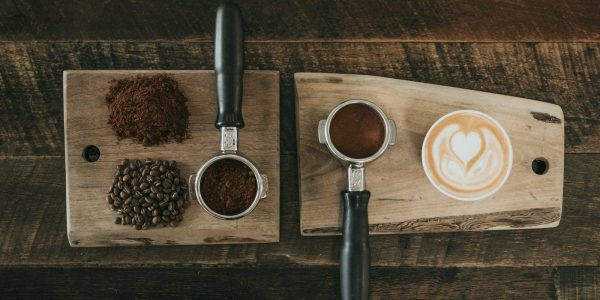 coffee beans beside coffee powder on brown wooden board