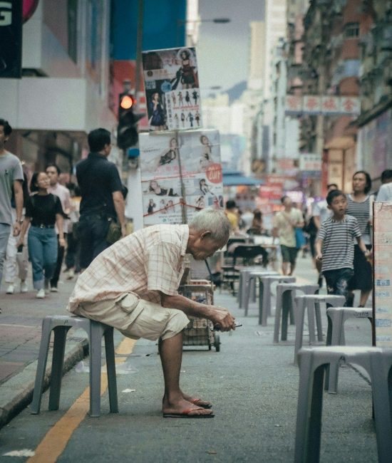 man seating on gray plastic stool