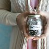 a woman holding a jar with savings written on it